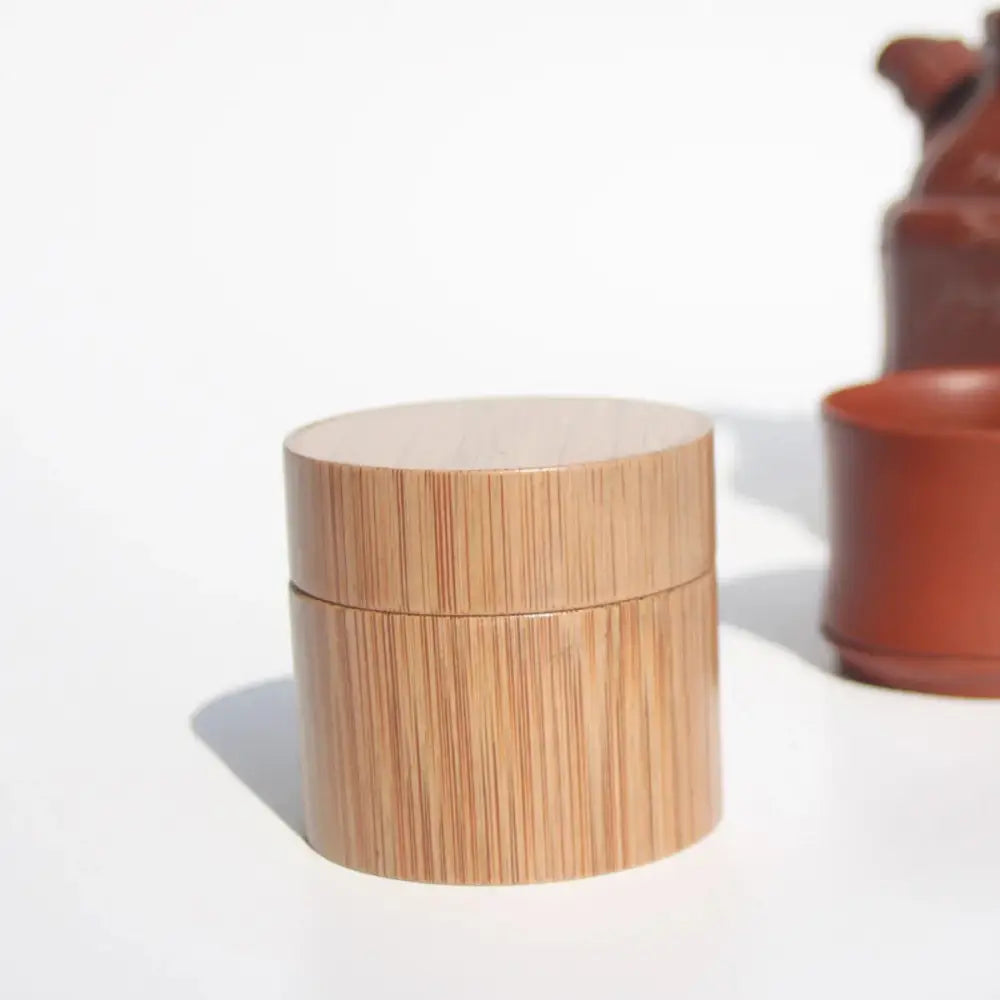Handcrafted eco friendly bamboo tea storage jar with matching lid featuring natural wood grain and light tan color
