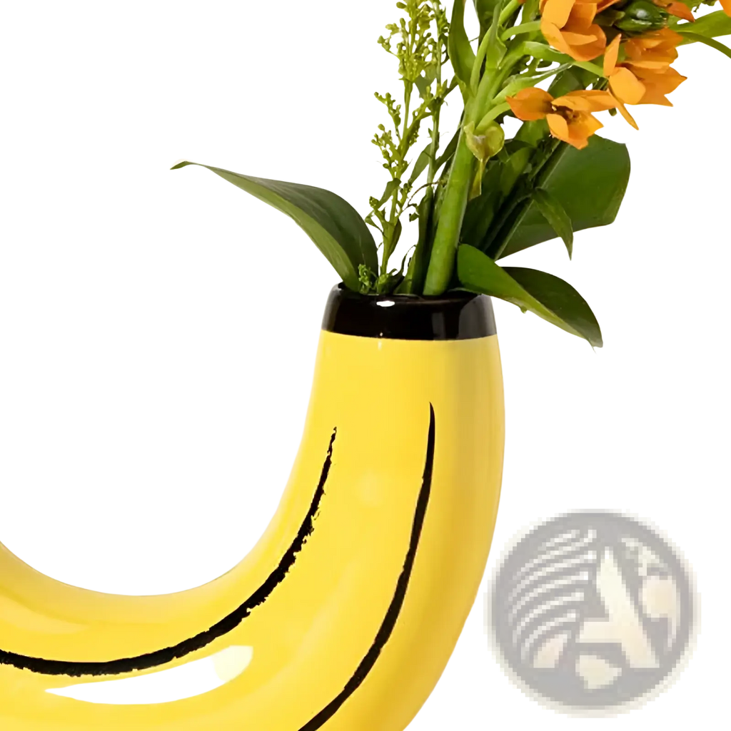 A bright yellow ceramic banana shaped vase with black curved lines holding orange flowers and green stems