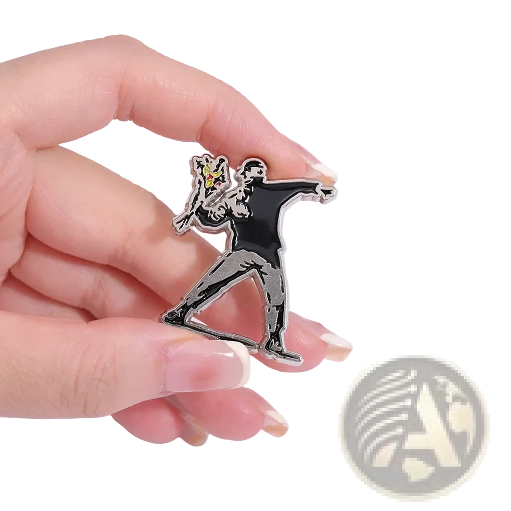 Black and silver enamel pin featuring a stylized figure holding a yellow spray can from Banksy street art badge