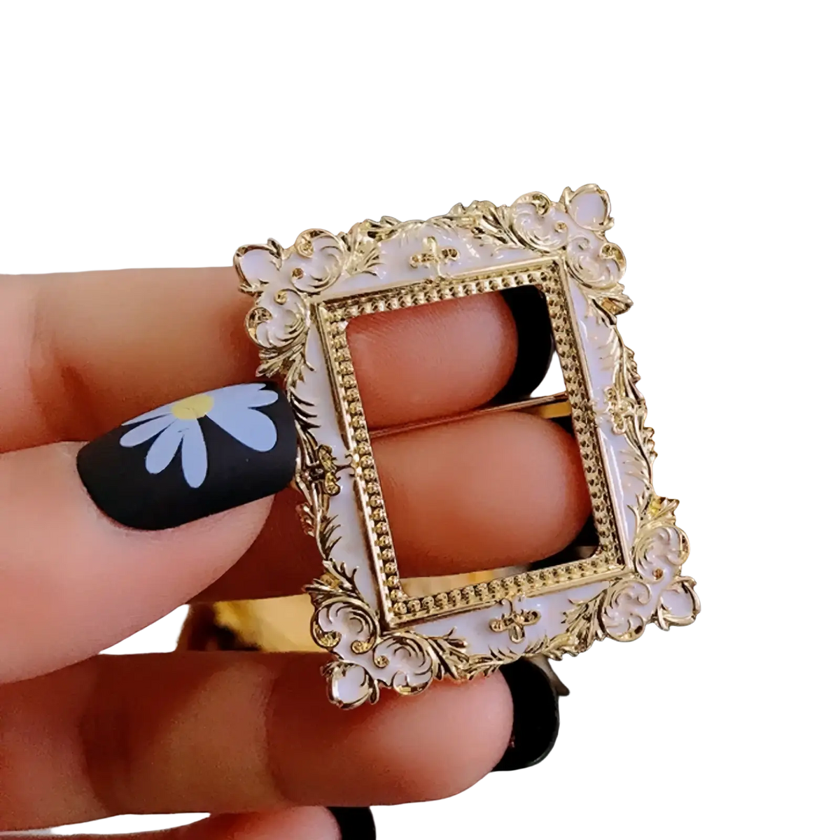 A delicate gold-toned and white enamel baroque david art picture frame brooch with ornate scrollwork detailing