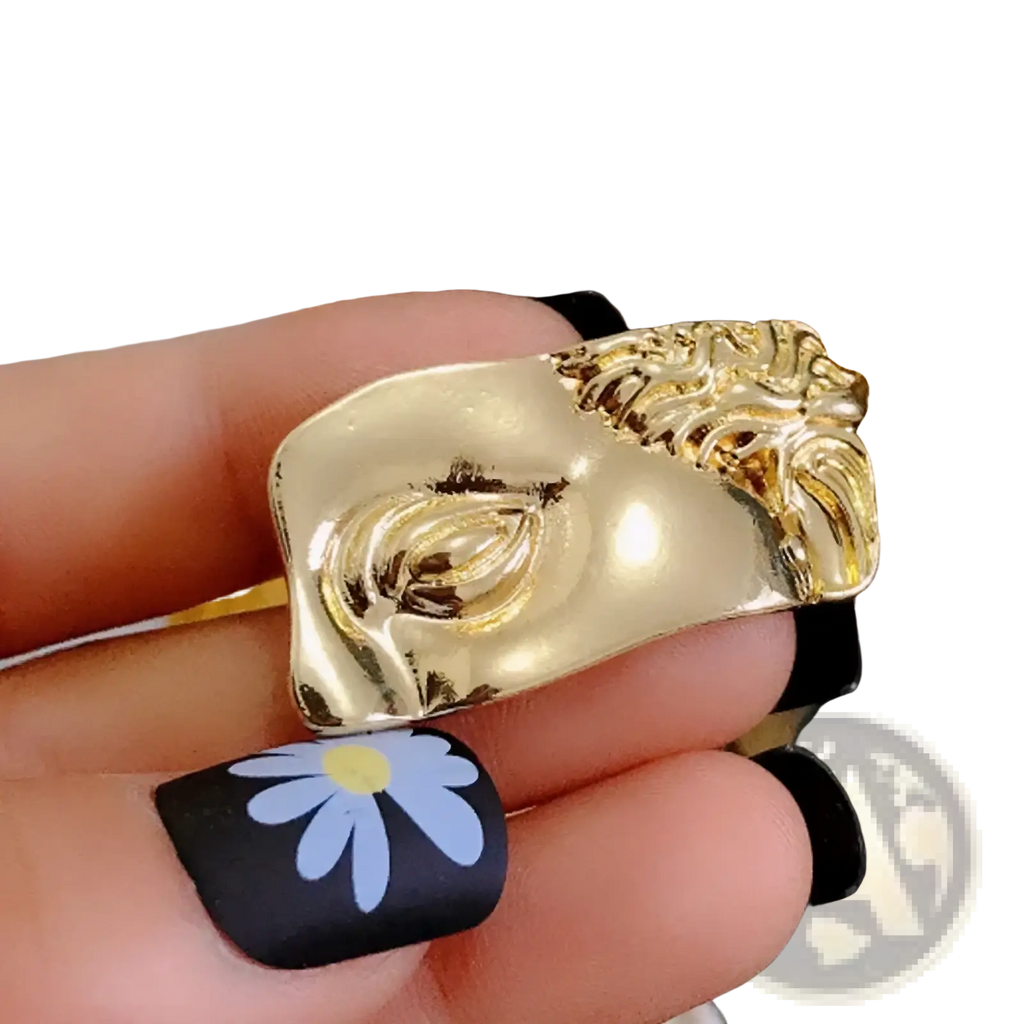 Gold-toned sculptural ring featuring a stylized face with intricate detailing and glossy finish baroque david art picture frame brooch