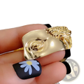 Gold-toned sculptural ring featuring a stylized face with intricate detailing and glossy finish baroque david art picture frame brooch