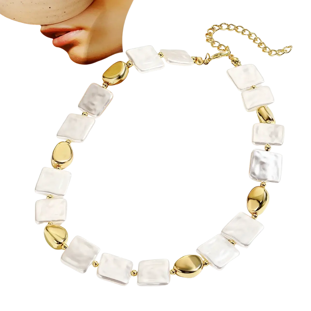 A baroque pearl gold chain necklace with alternating white mother-of-pearl squares and gold-toned oval accents