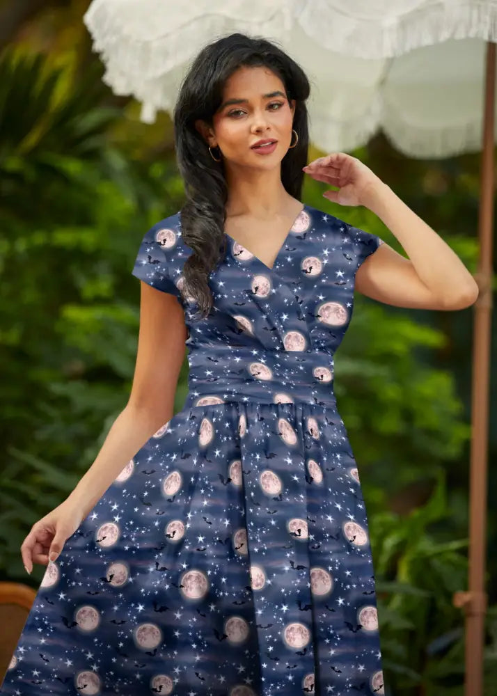 A navy blue vintage cotton wrap dress with pink moons stars and bats pattern called Bat Moon Greta