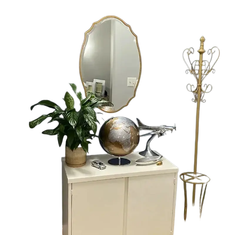 Shiny silver globe with detailed continents and metallic airplane model beside gold ornate oval bathroom mirrors style wall decor