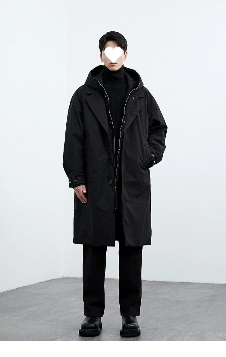 Men hooded trench coat in black with a sleek minimalist design and subtle zipper detailing suitable for winter wear.