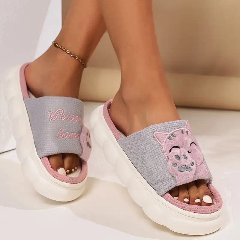 Pink and gray embroidered cat cartoon unisex anti slip slide slippers with plush paw print design on the strap.