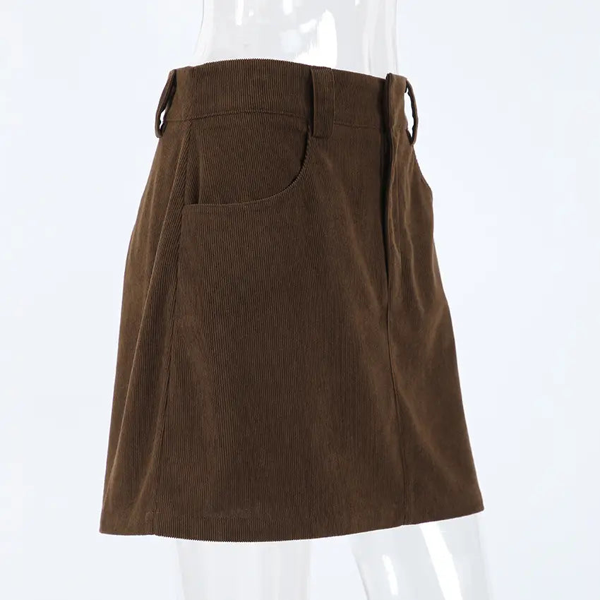 Brown corduroy mini skirt with a front pocket and side ties featuring a matching belt in a retro style.