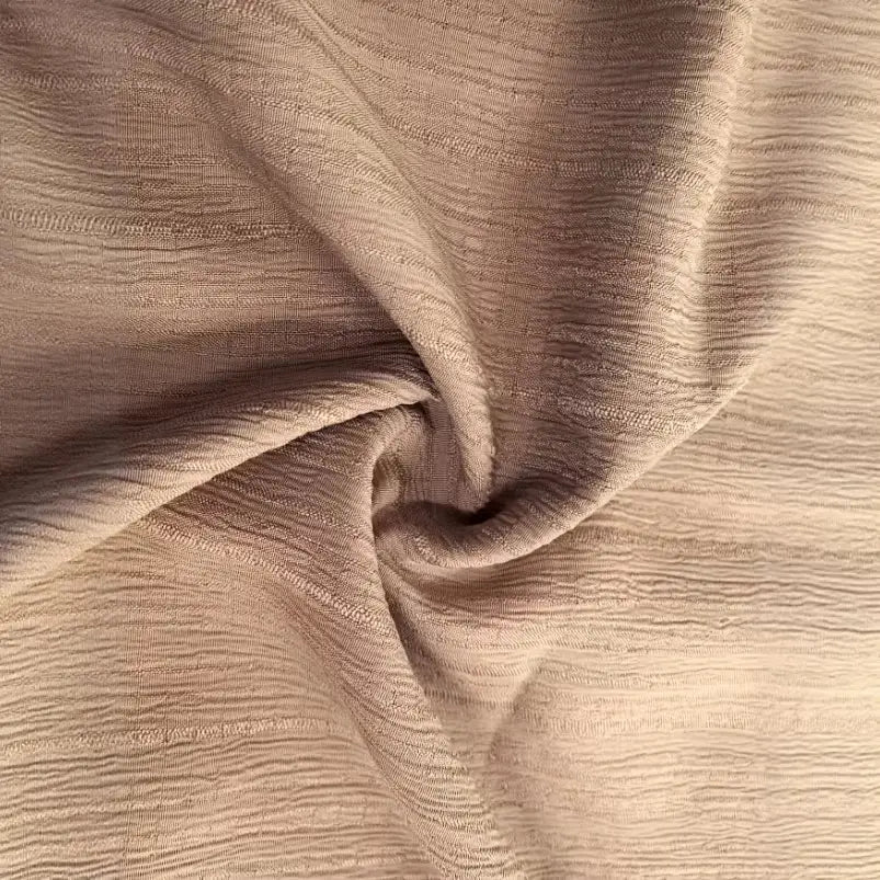 tejido de algodón arrugado color beige con una textura suave en relieve en un top tipo camiseta de canalé con escote en V