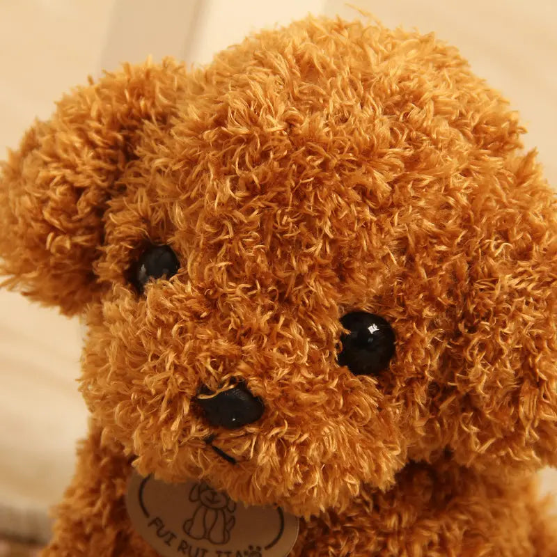 Un peluche de oso de peluche esponjoso color dorado-marrón con ojos y nariz de botón negros brillantes, presentado como un juguete de perro oso de peluche con diseño de caniche esponjoso.