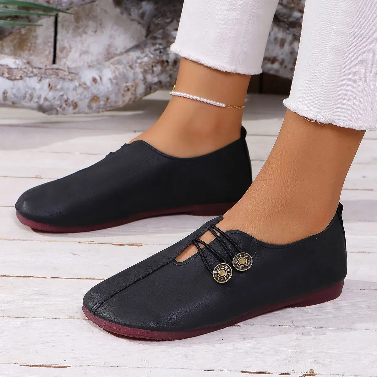 Women’s square toe lace-up leather and suede loafers in black with gold-toned button accents and a contrasting burgundy sole.