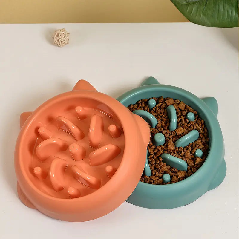 Deux gamelles pour chien à alimentation lente en forme de chat, de couleur corail et vert d’eau, avec des nervures en silicone moulées conçues pour prévenir le fait d’avaler trop vite et contrôler la vitesse de distribution.