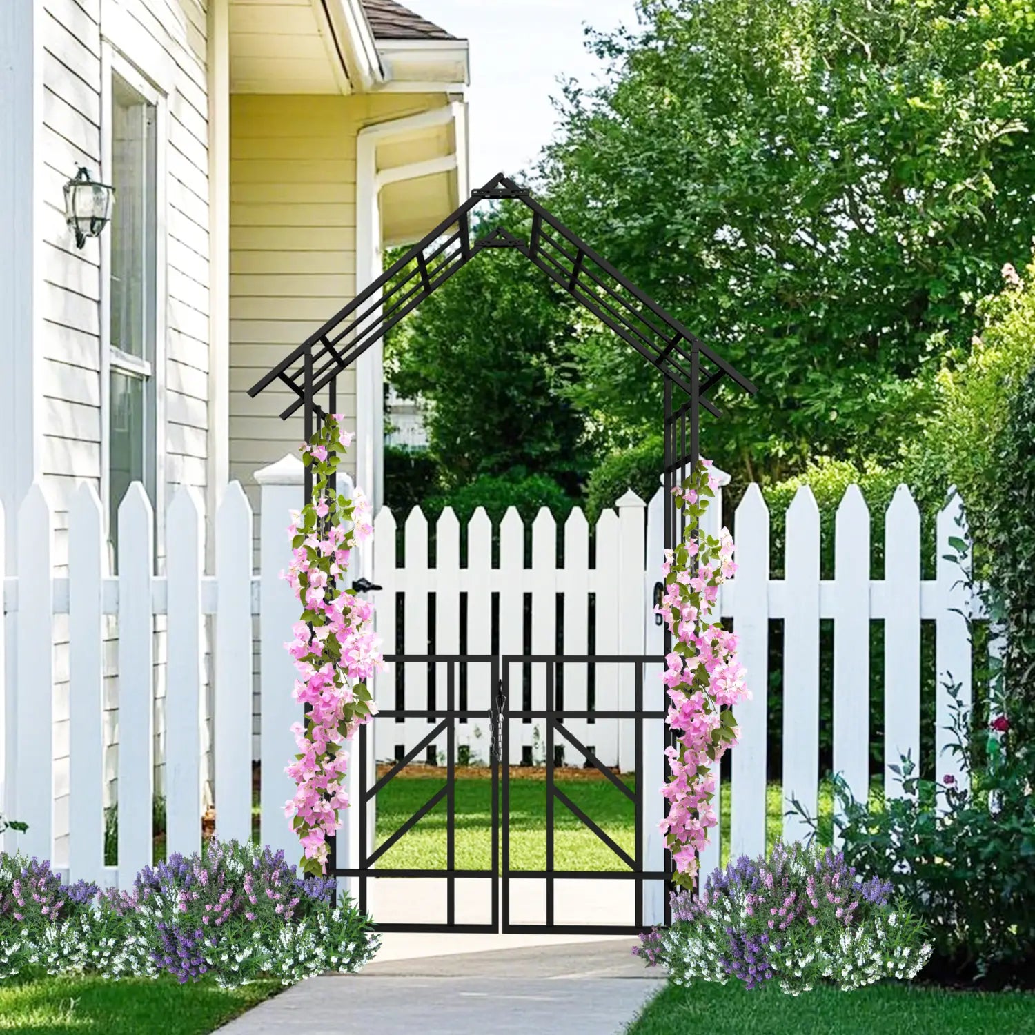 Black metal garden arch with gate featuring pink flowering vines on a black iron trellis standing 97 inches tall.