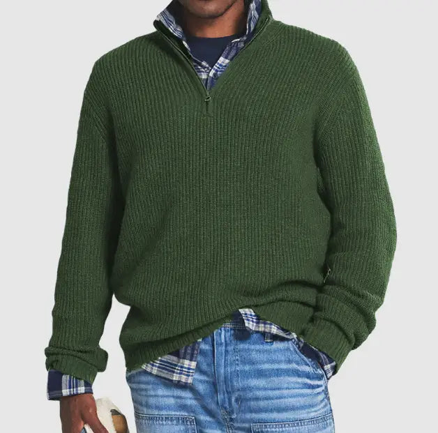 Pull en maille à col montant zippé au quart pour hommes, en matière côtelée vert foncé, porté par-dessus une chemise à carreaux.