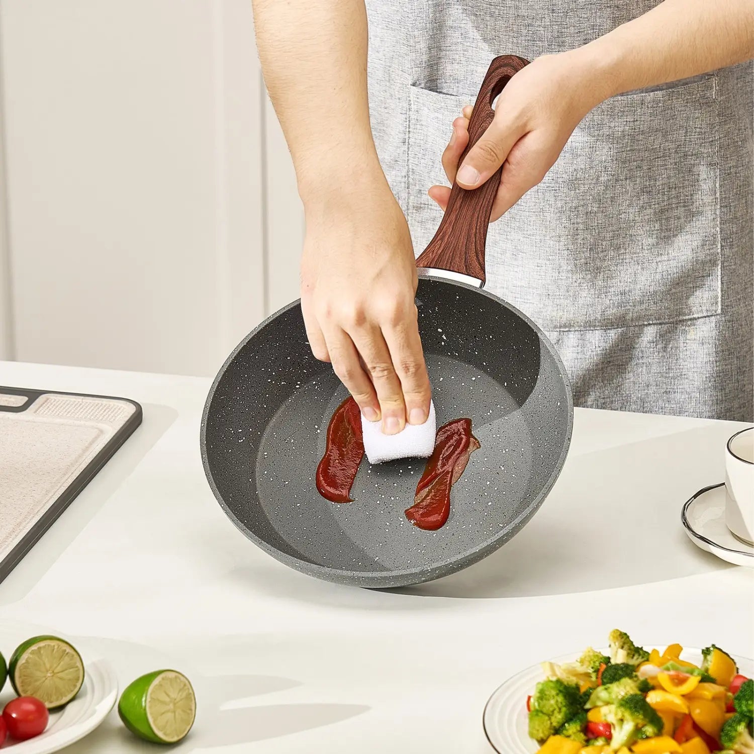 Gray speckled nonstick aluminum frying pan with wooden handle from a three-piece cookware set.