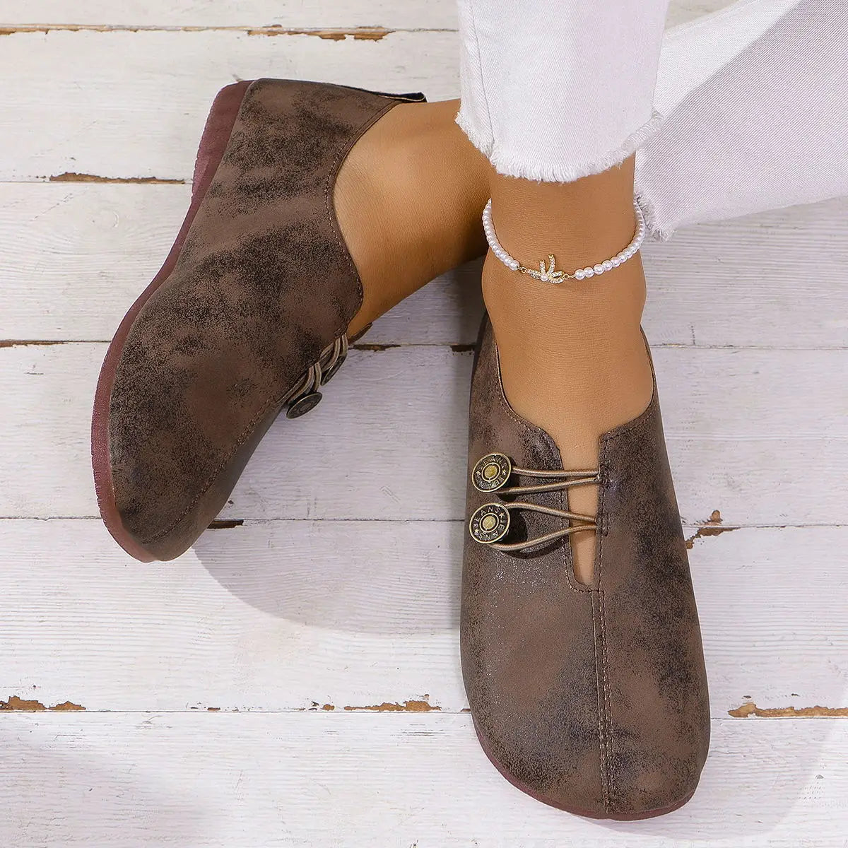 Brown suede ankle boots featuring decorative brass buttons and laces in a women’s square toe lace-up leather and suede loafers design.