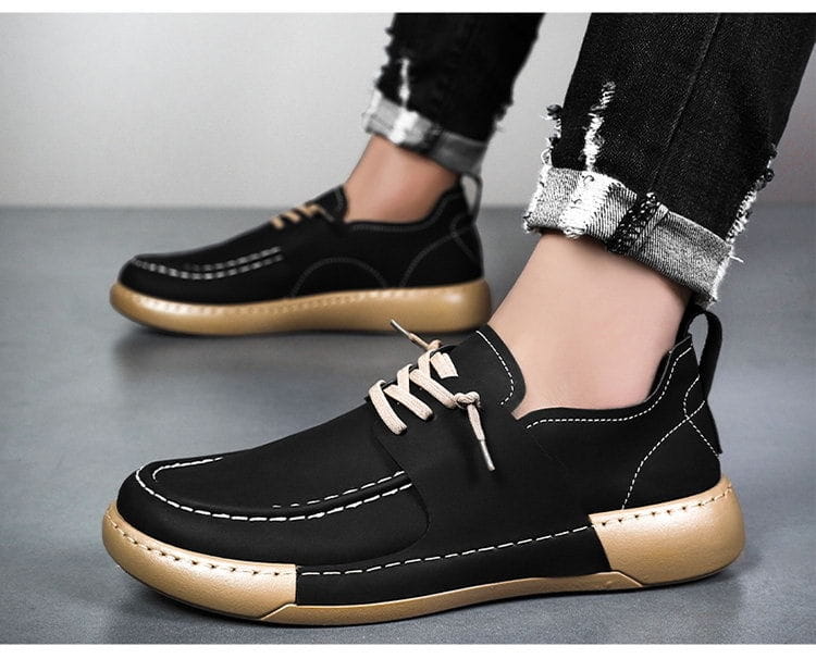 Chaussures en cuir style rétro britannique, élégance décontractée pour homme, noires, avec semelles marron et couture blanche, offrant un design à lacets.