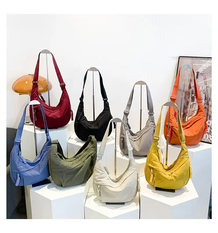 A collection of colorful large capacity nylon crossbody hobo shoulder bags in red black gray blue olive green beige and yellow made of lightweight nylon.