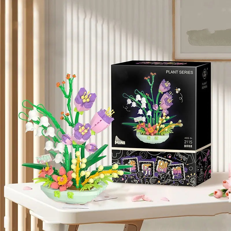 Un bouquet de fleurs en forme de plante en briques de type lego, assemblé de manière colorée et minutieuse, composé de fleurs violettes et roses avec des tiges vertes, présenté dans un pot en céramique d’une teinte menthe claire provenant du jeu de blocs de construction « Bouquet floral violet ».