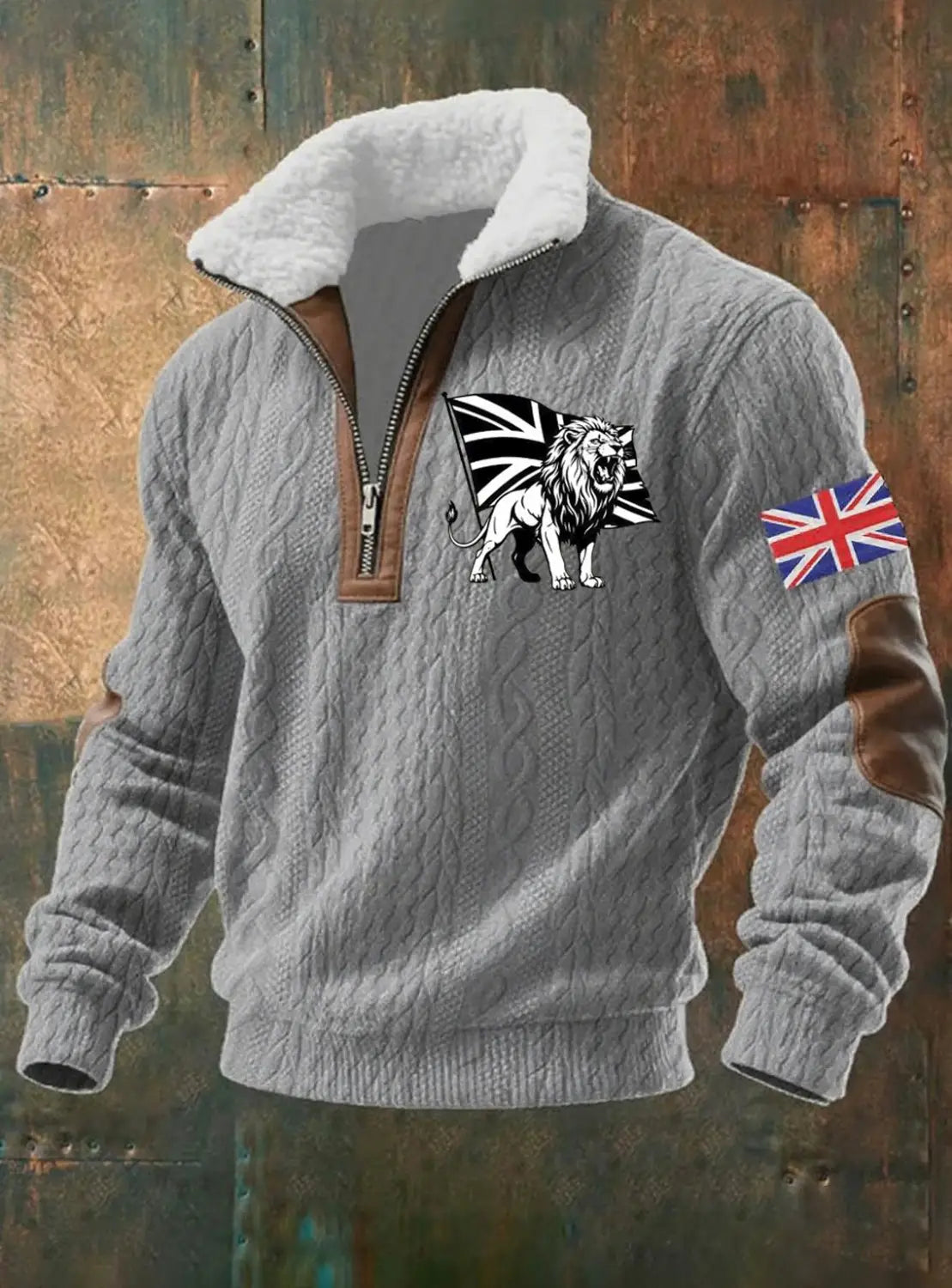 Suéter para hombre de media cremallera con cuello de borrego color gris, diseño de punto trenzado, cuello de borrego blanco, detalles en cuero marrón y emblema de león negro y blanco sobre una bandera Union Jack en el pecho, con un parche de bandera británica en la manga izquierda.