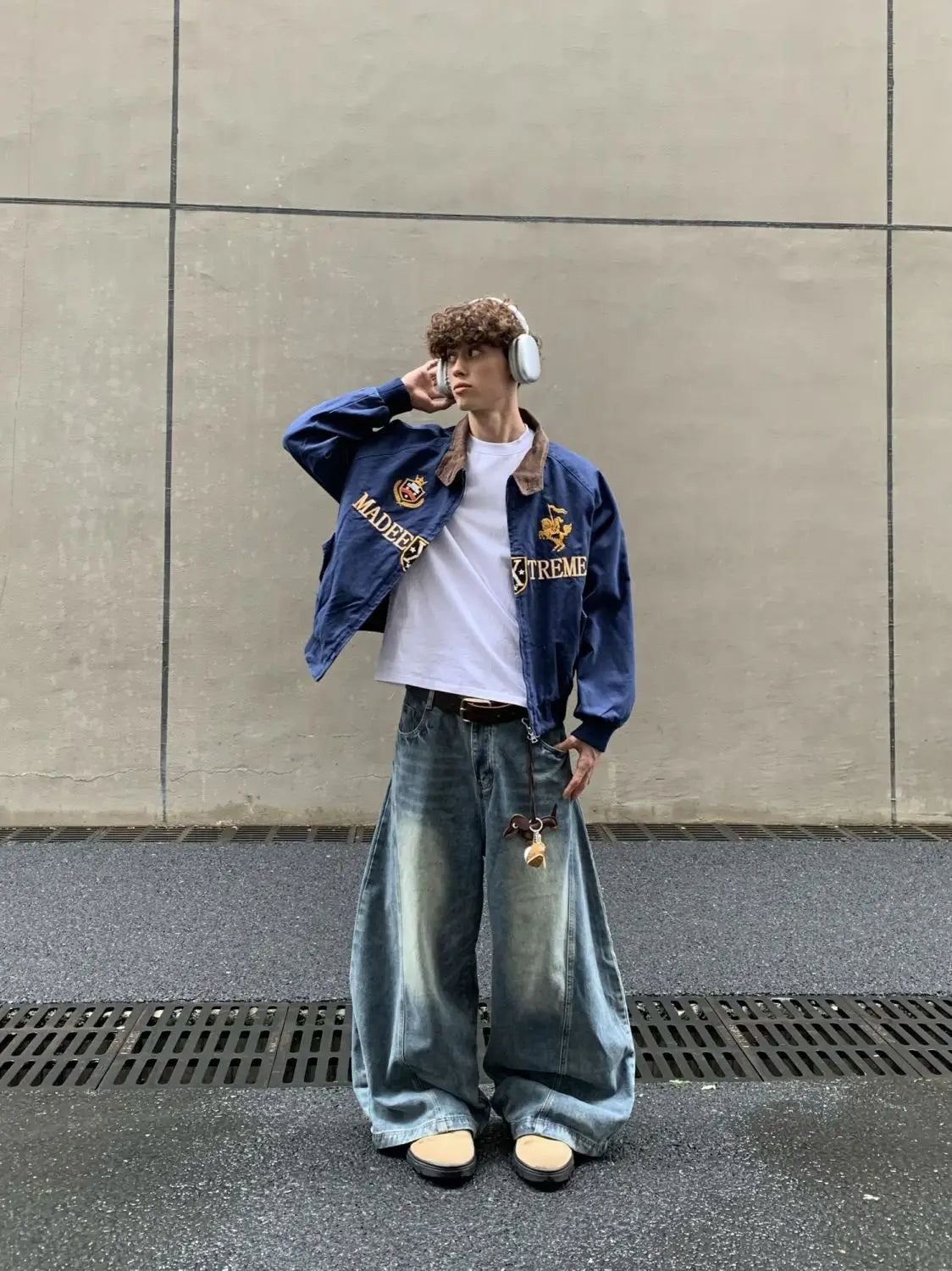 Chaqueta corta tipo béisbol azul marino en denim azul con parches bordados y forro de cuello de piel marrón.