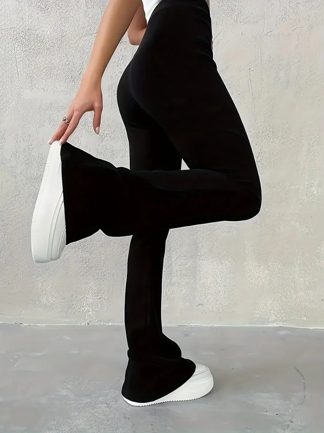 Schwarze hoch geschnittene Ripp-Flared-Leggings mit einer eleganten, körpernahen Silhouette und ausgestellten Beinen.