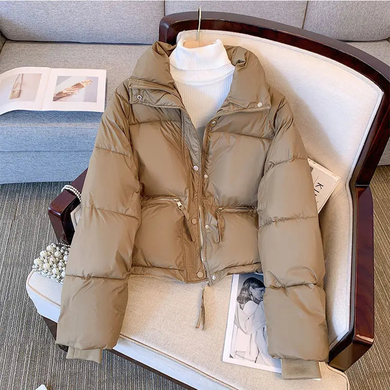 Beige women winter padded cotton outerwear jacket with a hood, front zipper closure, and two side pockets.