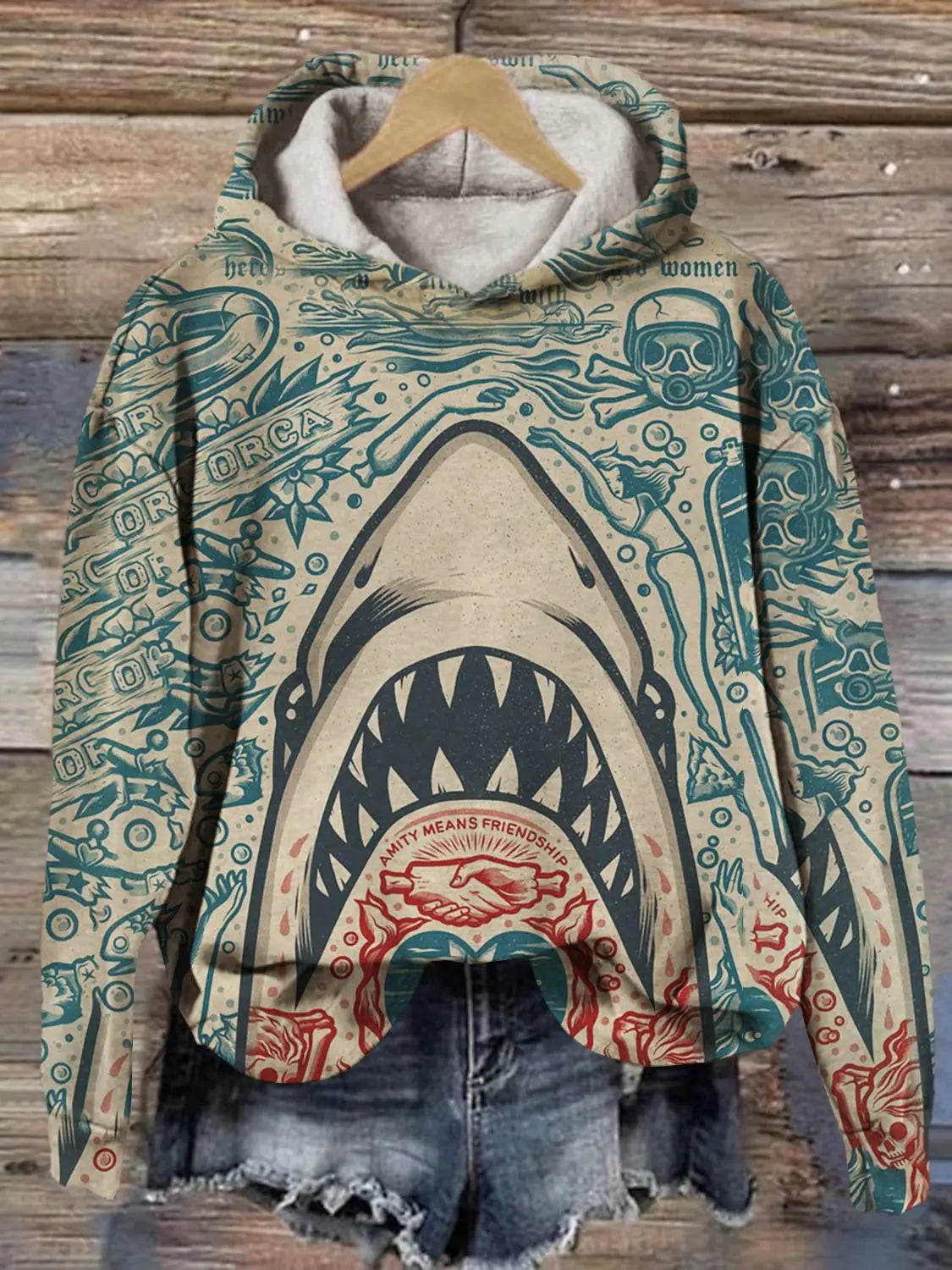 Men’s graphic print pullover hooded sweatshirt featuring a beige and teal shark-themed design with bold black outlines and red accents around the mouth area.