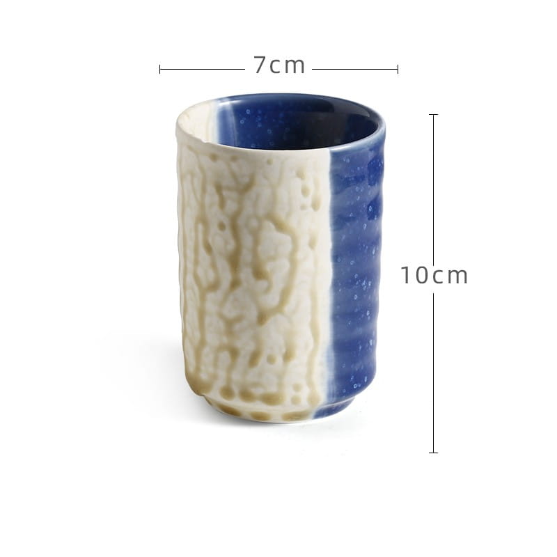 A Japanese ceramic mug with a textured off-white exterior with subtle beige veining and a solid cobalt blue vertical stripe designed as a retro hand-painted tea cup with a 250ml capacity.