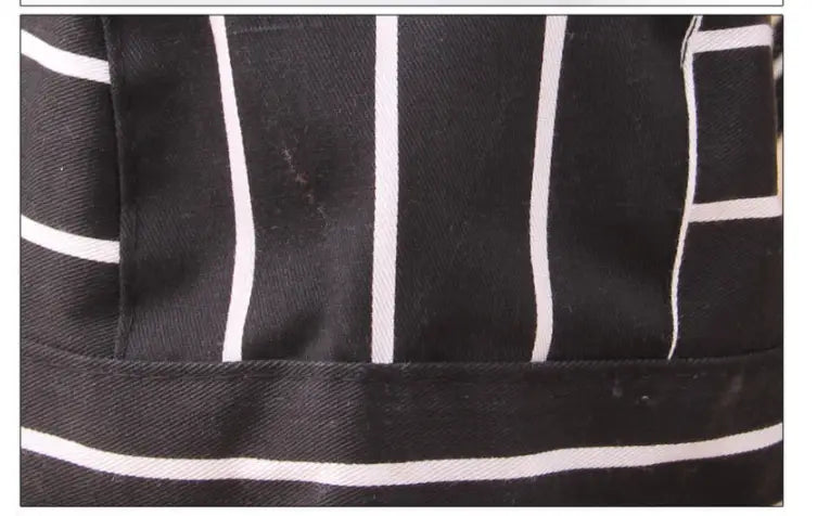 Black canvas apron with bold white vertical stripes featured alongside chef hat adjustable kitchen work cap multi pack for professional culinary use.