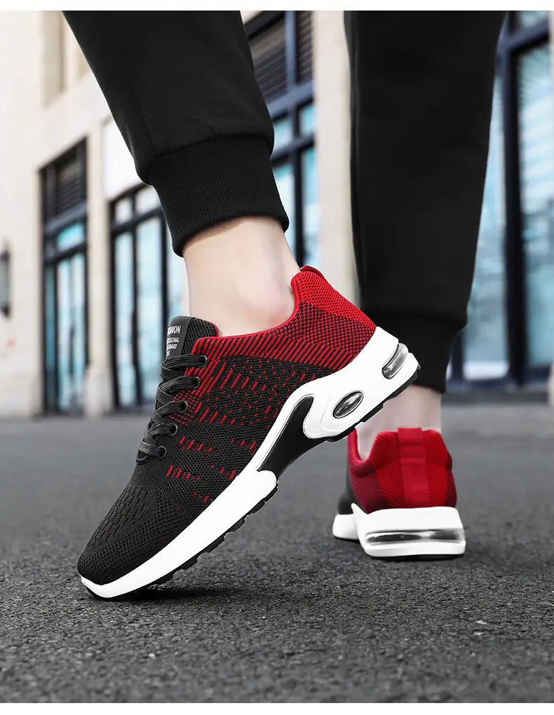Baskets décontractées pour hommes en mesh flyknit à coussin d’air, en rouge et noir, en tricot avec semelle intermédiaire blanche et unité d’amorti par coussin d’air.