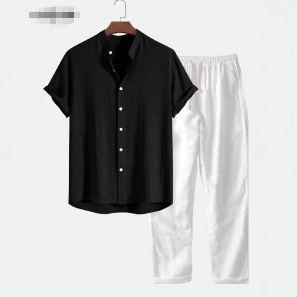 Chemise pour homme à manches courtes noire, avec col classique et boutons blancs, présentée sur un cintre en bois dans le cadre d’un ensemble chemise à manches courtes et pantalon.