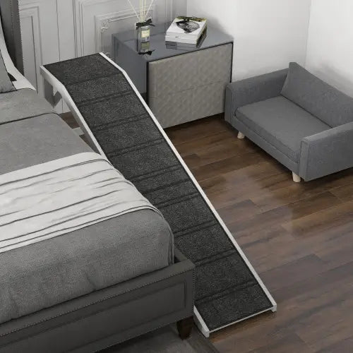 Rampa para cama de perro de color gris con textura, con alfombra antideslizante y ribete blanco, diseñada para facilitar el acceso de las mascotas