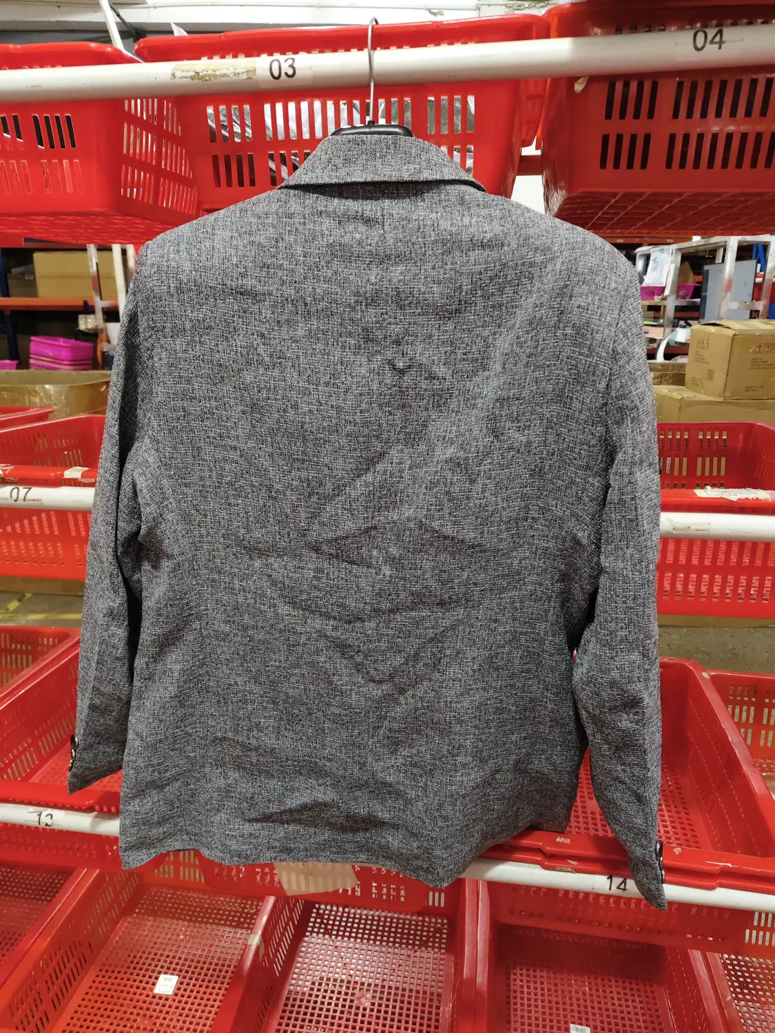 Gray textured men’s casual thin blazer spring jacket hanging on a hanger.