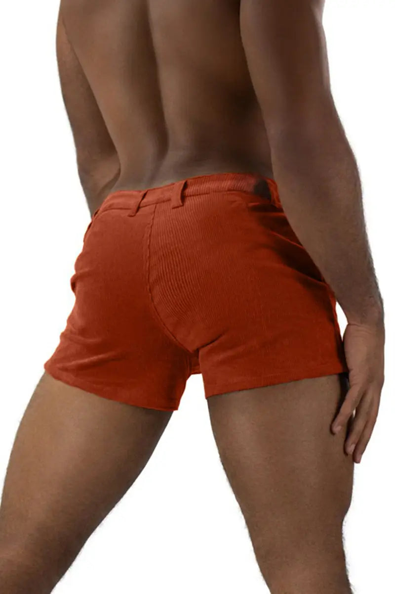 Men corduroy beach shorts in orange featuring a belt loop and a back pocket shown from the back side.