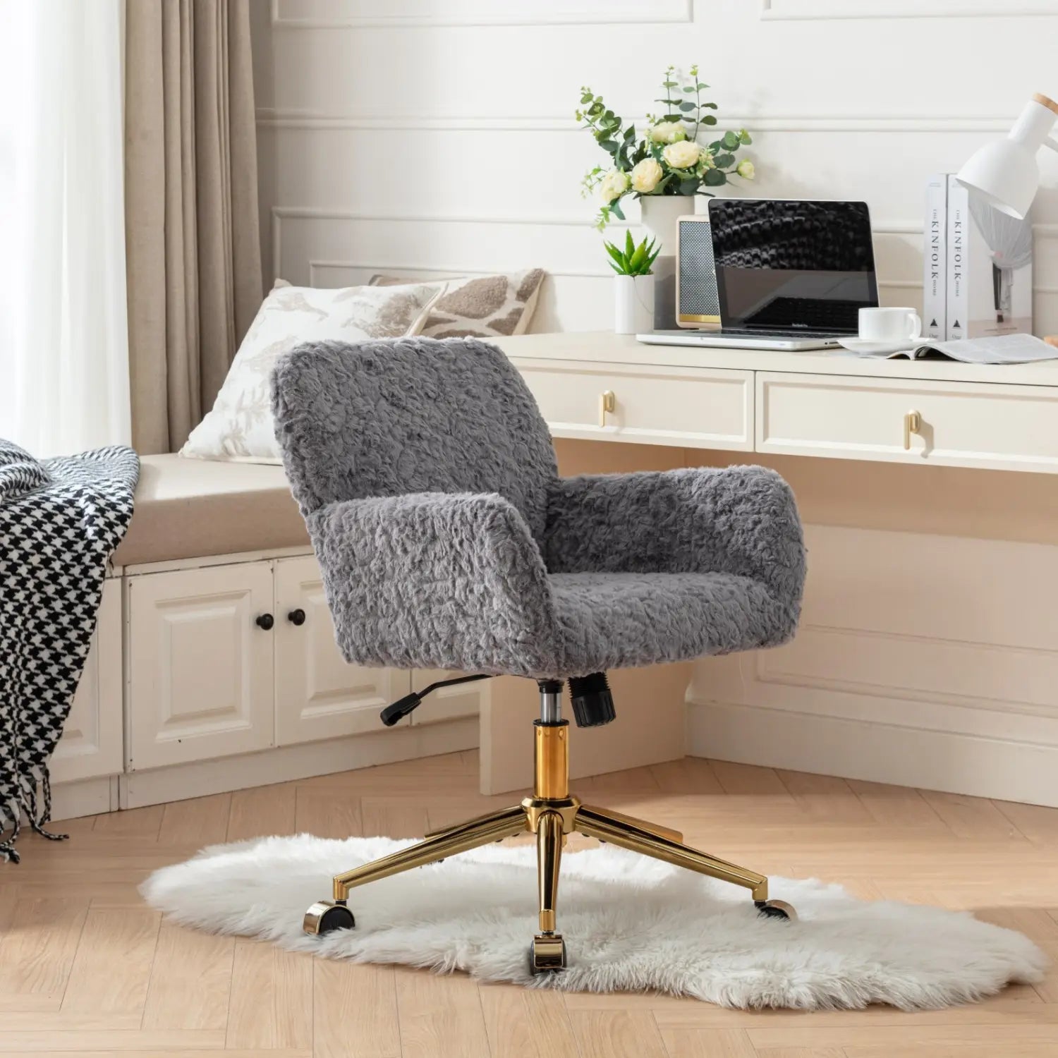Chaise de bureau en fausse fourrure gris clair, présentant une texture duveteuse avec une base en métal doré et des roulettes pour une mobilité aisée.