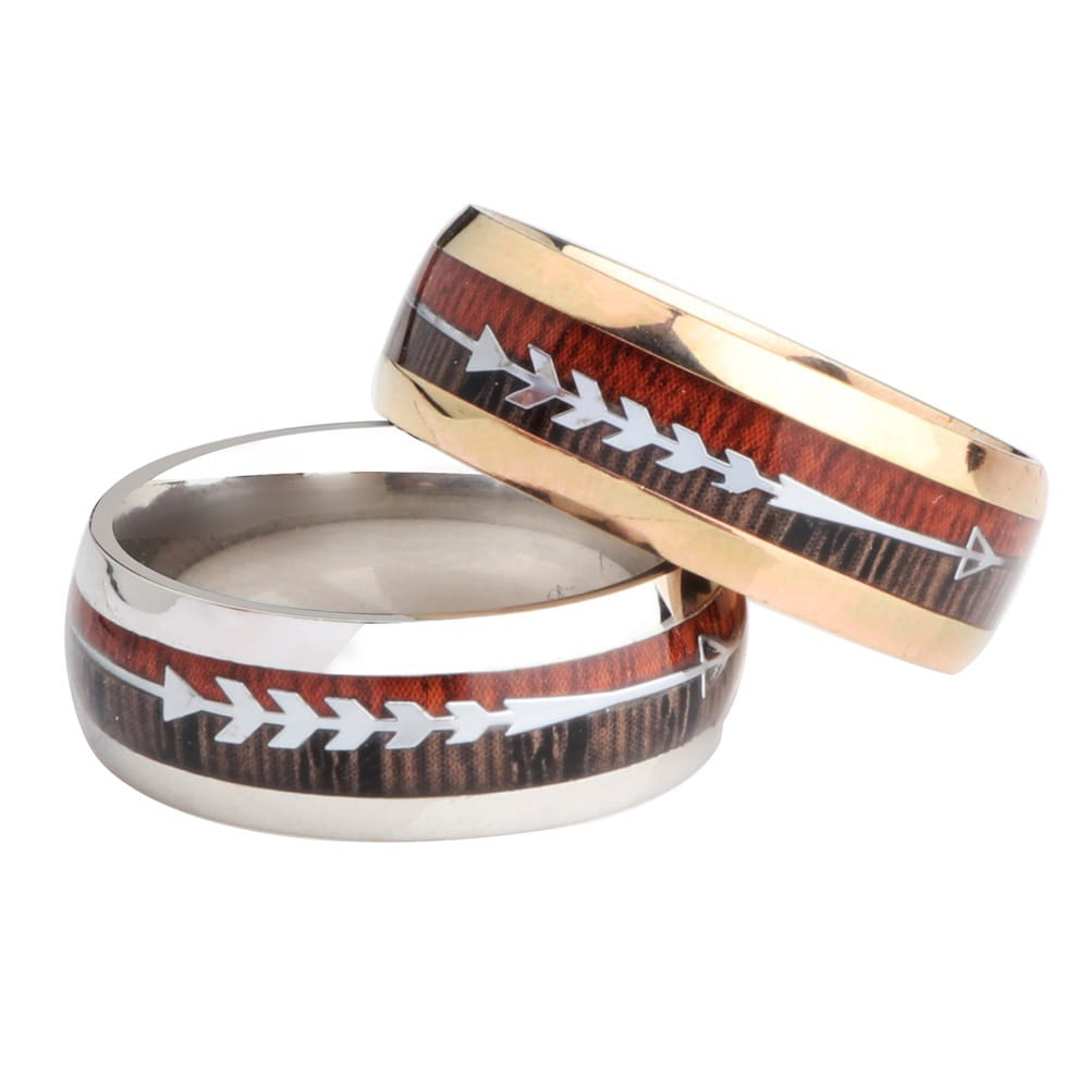 Two wedding bands in rose gold and silver stainless steel featuring a central dark wood grain band with white arrowhead inlaid designs.