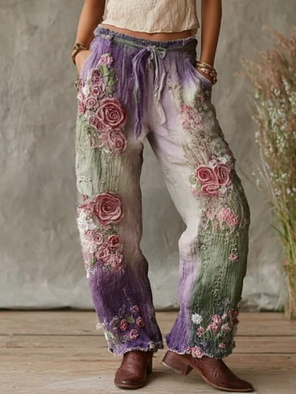 Pantalon décontracté ample à jambes larges à imprimé numérique de style bohème, orné de roses roses et violettes brodées à la main sur un tissu vert lavande et blanc délavé.