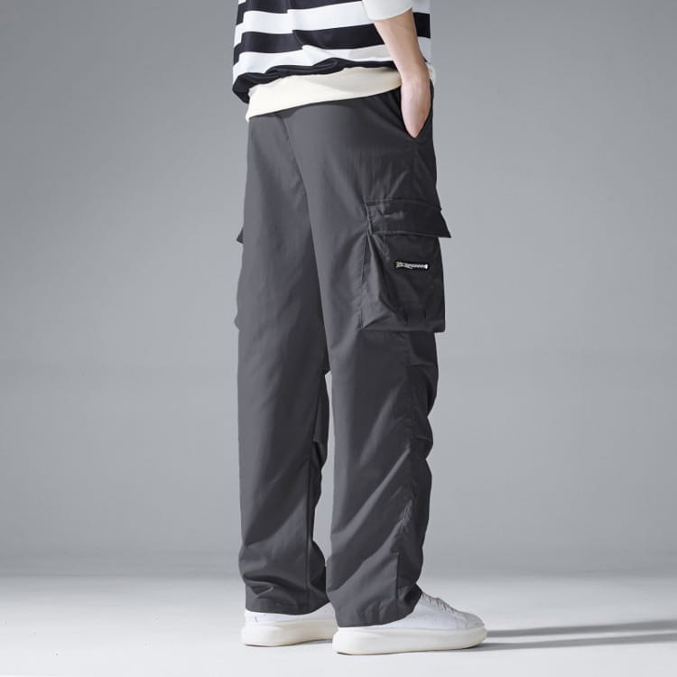 Mens multi pocket cargo workwear pants in dark gray with multiple pockets and a subtle brand logo on the thigh.