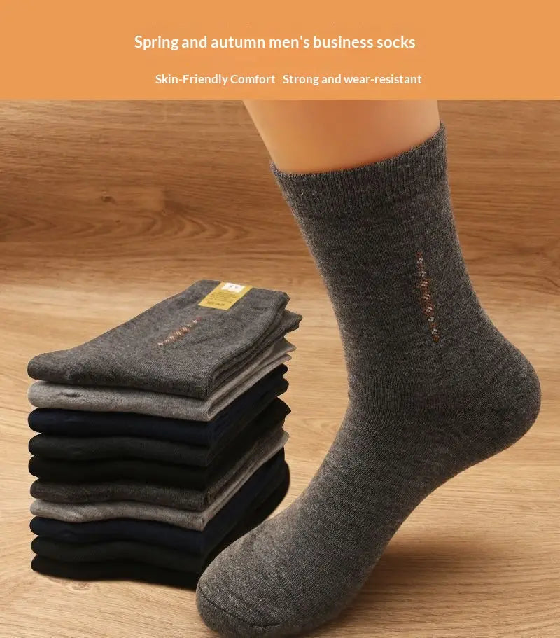 A pair of dark gray textured men mid calf crew business socks with ribbed cuff and subtle embroidered detail on the side.