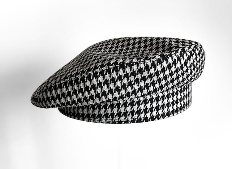 Chapeau en laine béret noir pour peintre, pour femmes, présentant un motif pied-de-poule noir et blanc avec une calotte structurée légèrement arrondie.