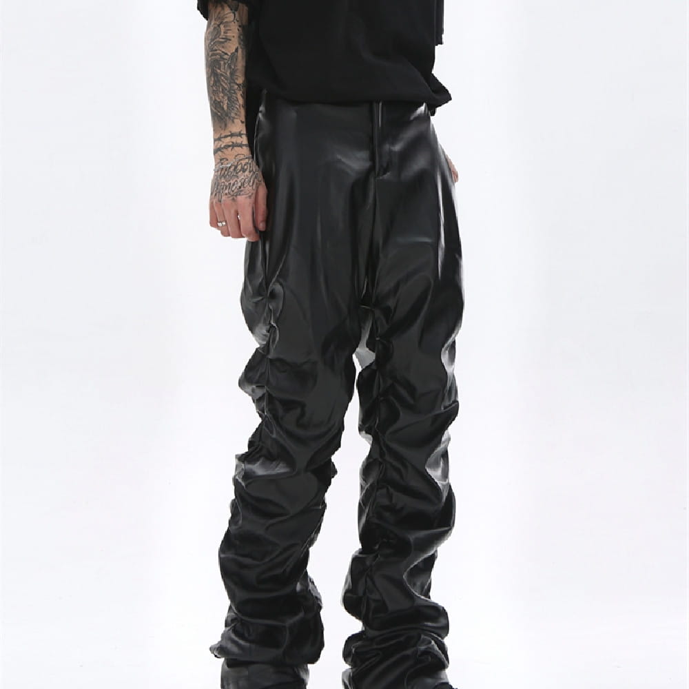 Men’s black ruched glossy faux leather tapered pants with a slouchy design.