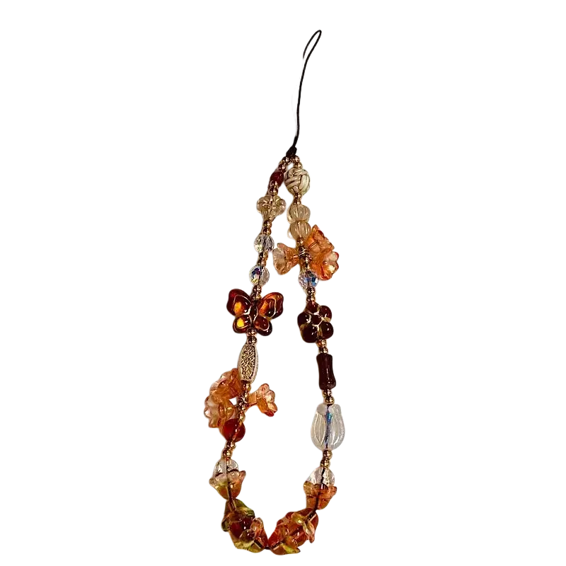 A delicate beaded phone charm strap with translucent amber and orange glass beads featuring butterfly and flower charms