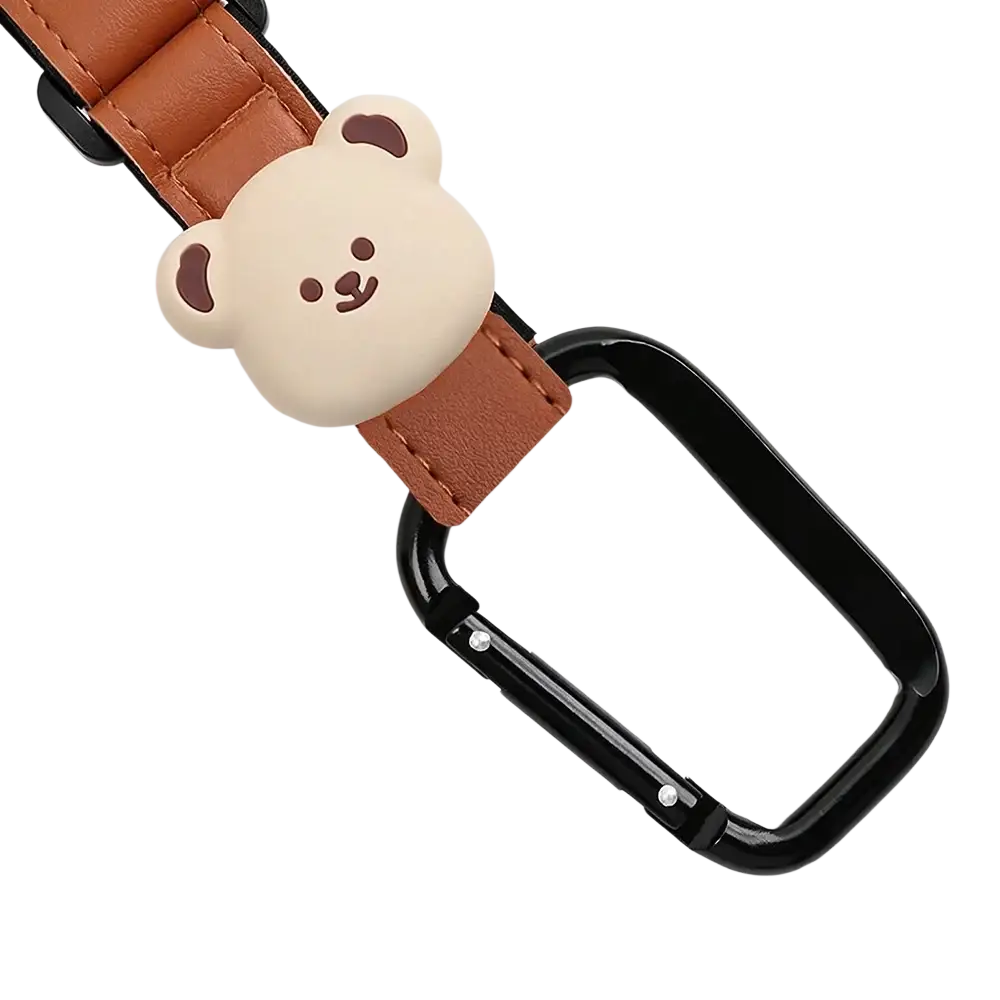 A cute beige bear-shaped pu leather charm attached to a brown strap and black carabiner bear stroller hooks bag hanger