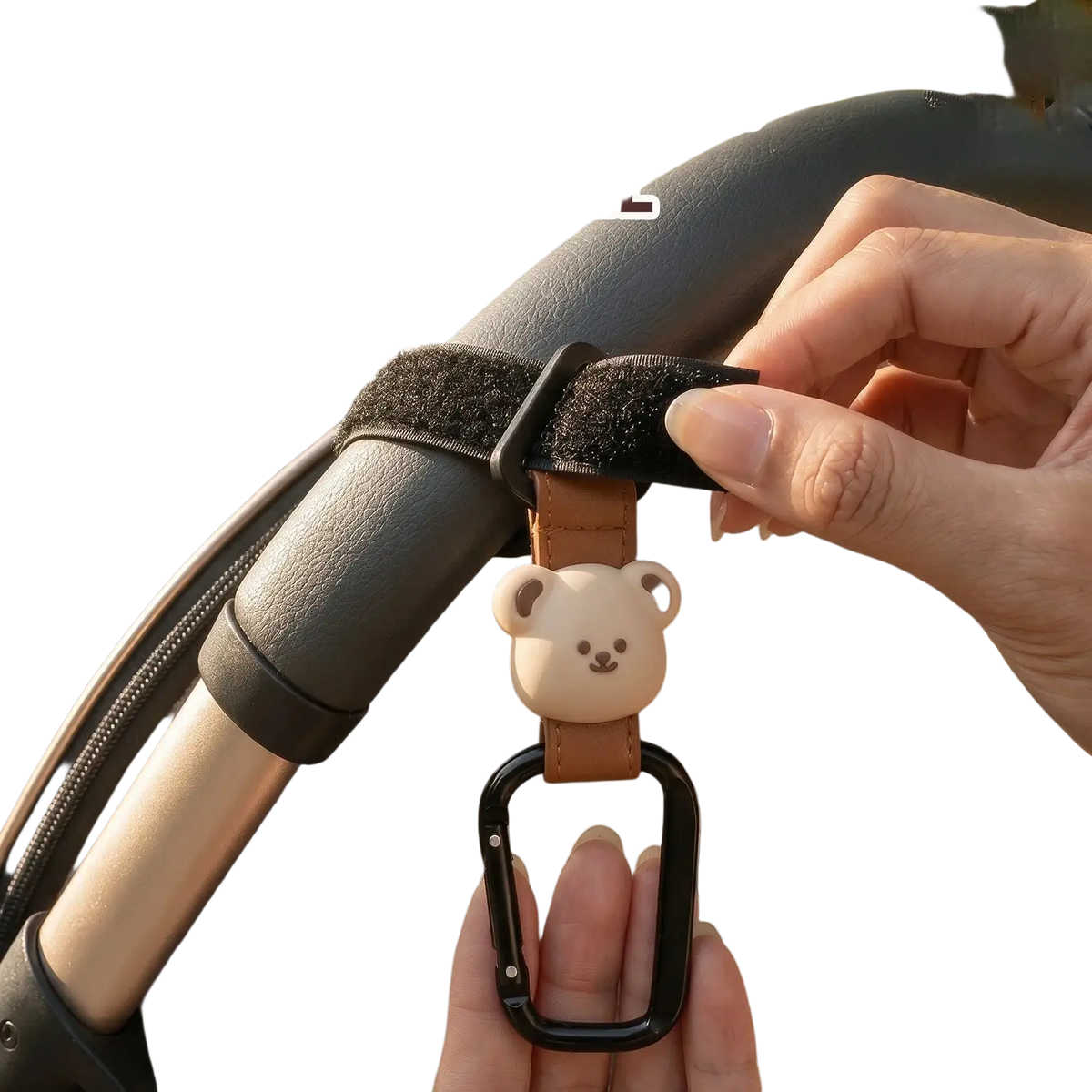 A beige bear-shaped charm on a brown pu leather strap with a black carabiner clip for bear stroller hooks bag hanger