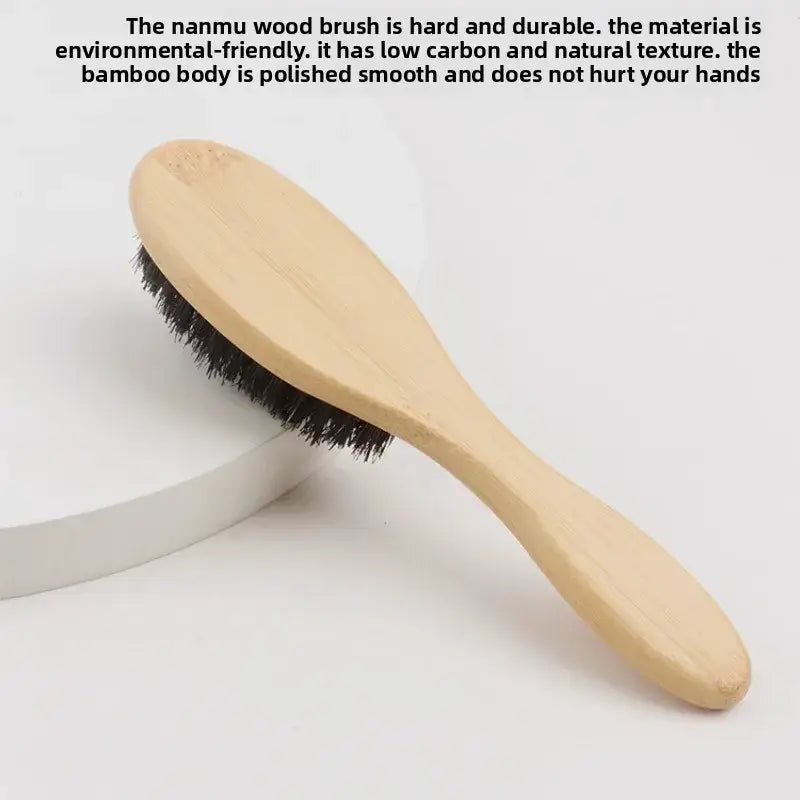 A light-colored bamboo wood beard brush with dense black boar bristle and ergonomic wood handle grooming tool