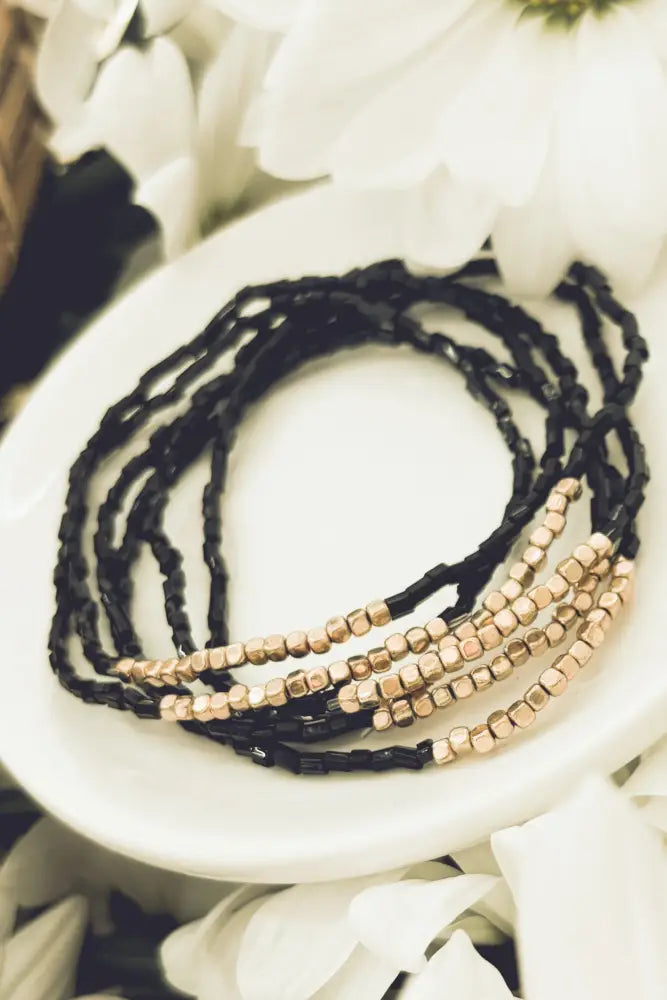 Elegant black and rose gold layered beaded bracelet set featuring multiple strands with polished bead accents