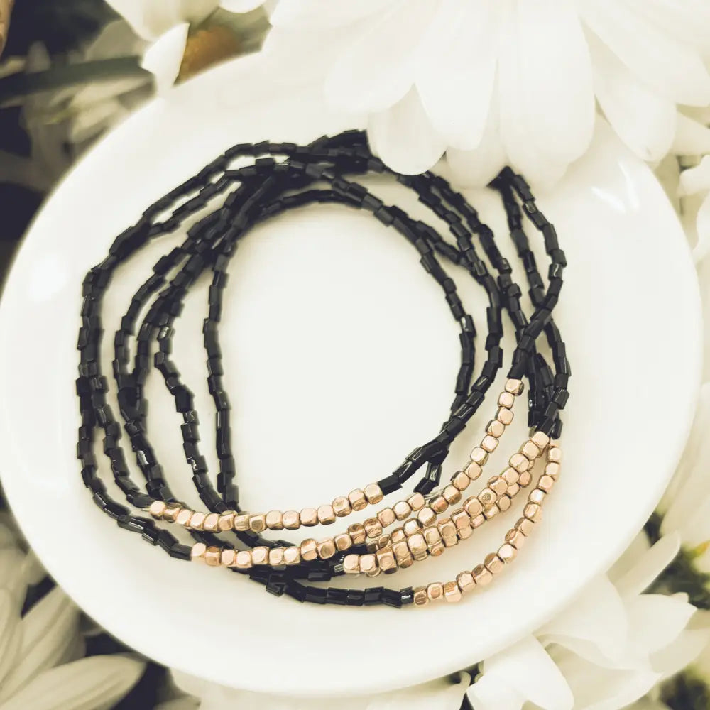 Elegant black and rose gold layered beaded wrap bracelet with geometric design in black and rose gold tones