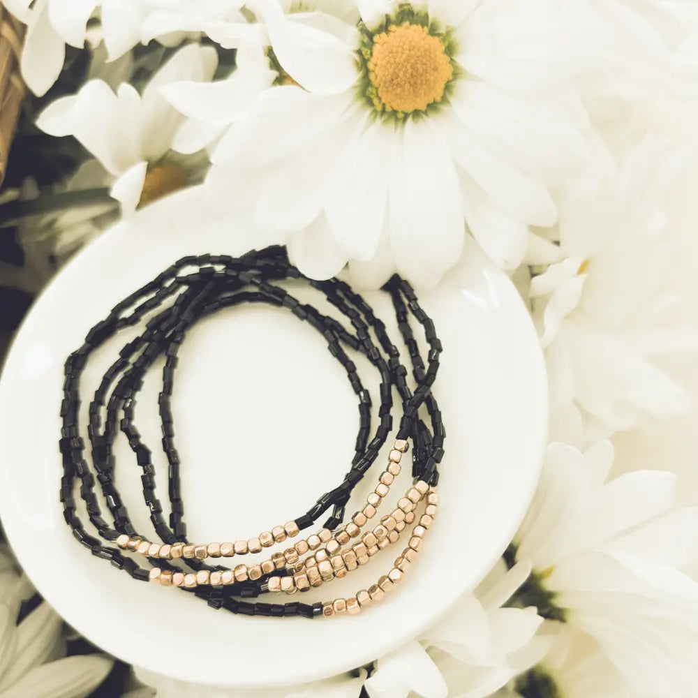 Elegant black and rose gold layered beaded bracelet set featuring black and gold beads for stylish wristwear