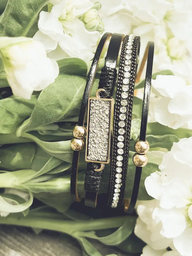 Crystal layered black leather bracelet with gold accents featuring a rectangular crystal-encrusted charm
